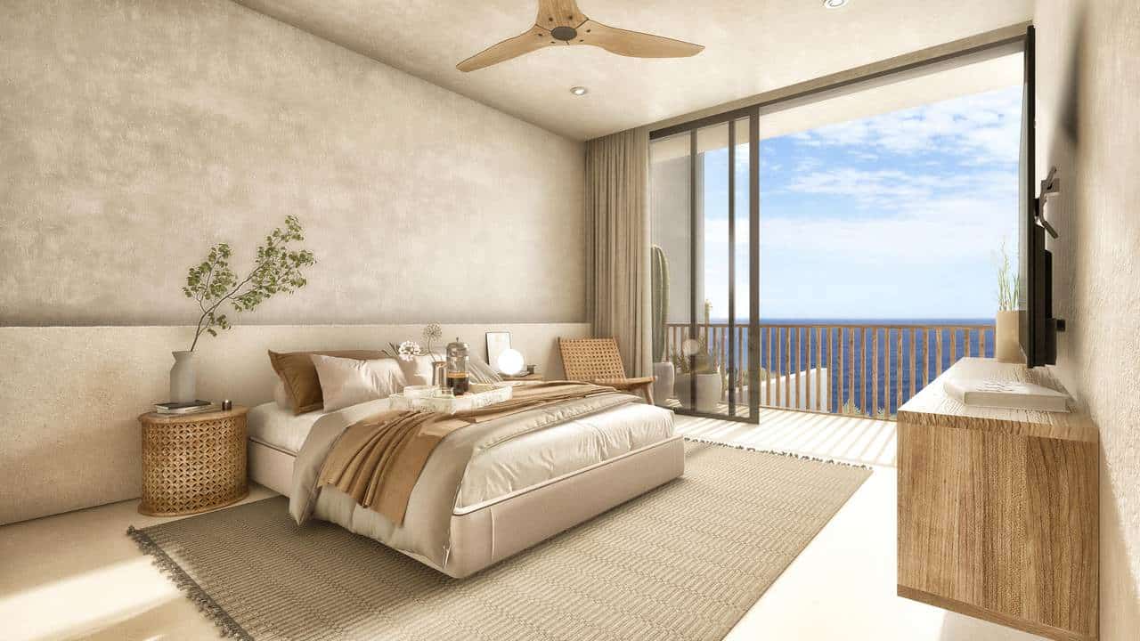Spacious Pedregal Bedroom With A Large Balcony View Of The Ocean, Modern Decor, Neutral Tones, And Natural Sunlight Streaming Through Sliding Glass Doors.