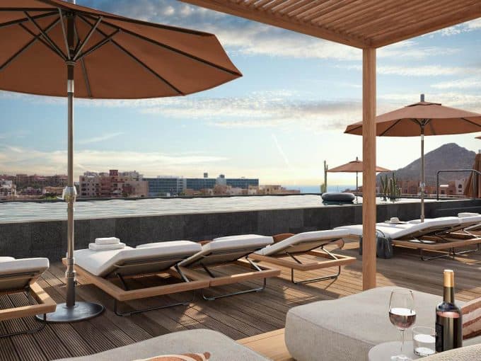Luxurious Pedregal Rooftop Terrace With Lounging Chairs, Umbrellas, And Panoramic City Views At Sunset. Ideal For Relaxation And Enjoying The Beautiful Scenery.